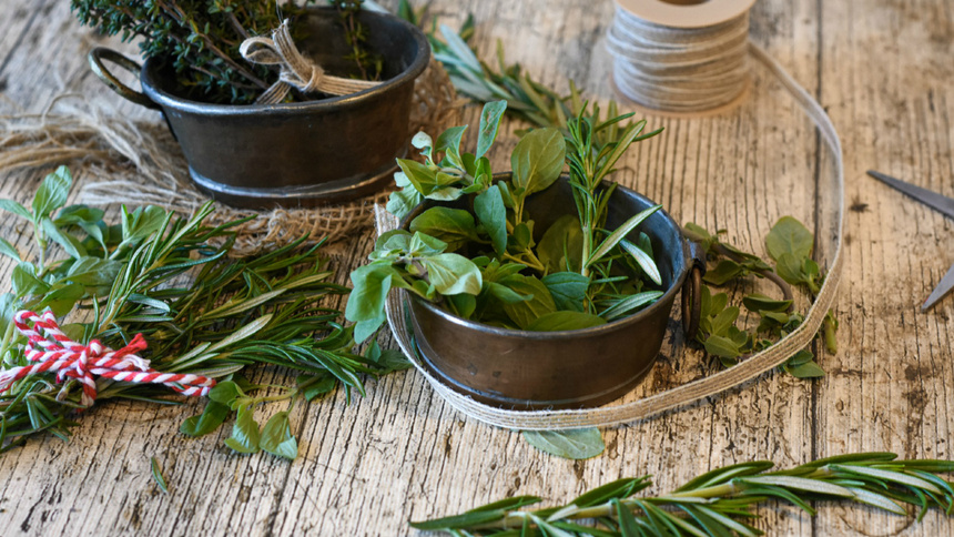 Thymian, Rosmarin, Oregano und Basilikum liegen auf einem Tisch