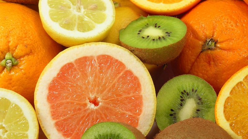 Conseil santé système immunitaire: des oranges, des citrons et des kiwis coupés en deux, présentés face contre le haut.
