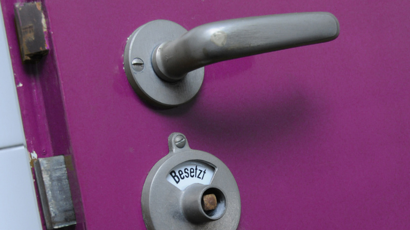 Une porte de toilettes fuchsia.