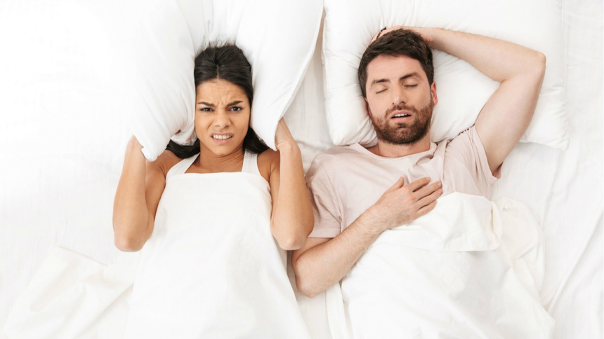 Schlafen, Schnarchen: Paar liegt im Bett, die Frau ist wegen ihrem schnarchenden Partner schlaflos.