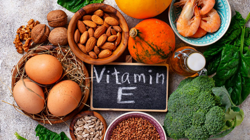 Différents aliments avec un tableau sur lequel vitamine e est écrit