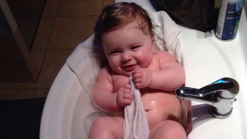 Bains bébé: un bébé se baigne dans un lavabo