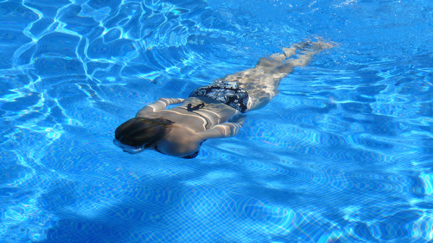 Une femme en costume de bain nage dans l'eau