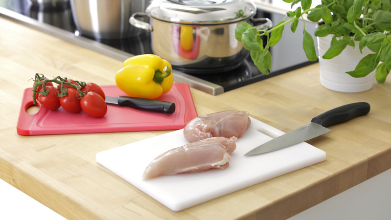 Wohnen, Hygiene, Sauberkeit: Zwei Schneidbretter auf dem Küchentisch mit Fleisch und Gemüse