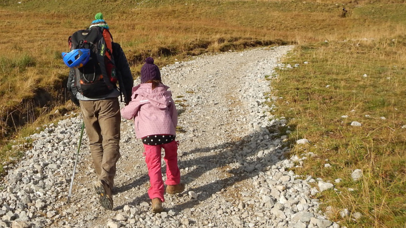 Un père et sa fille se promènent sur un chemin en pierre.