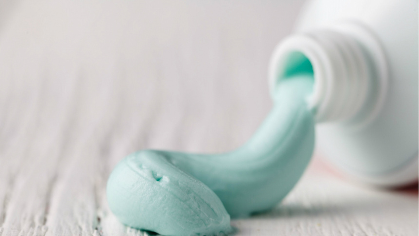 Un tube de dentifrice avec de la pâte bleue qui s'écoule de l'ouverture.