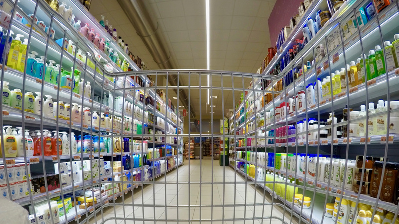 Kosmetik, Pflegeprodukte, Schönheit: Wir blicken durch einen leeren Einkaufswagen auf Regale voller Pflegeprodukte in einem Supermarkt