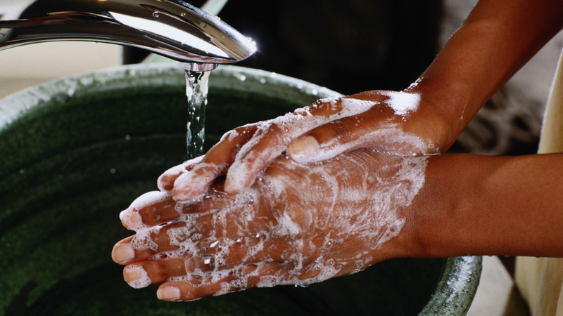 Gesundheitsvorsorge, Grippe, Viren: Frauenhände, eingeseift und unter den Wasserhahn gehalten