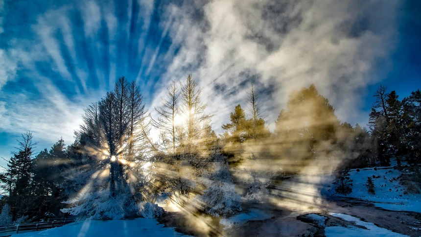 Un paysage hivernale avec une montagne et du soleil