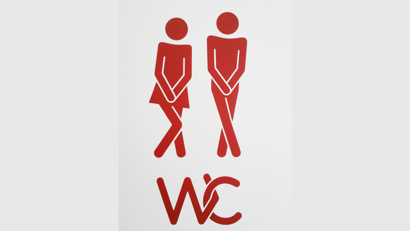 Blasenentzündung, Naturheilmittel, Komplementärmedizin: WC-Schild mit einer Frauen und einer Männerfigur, beide haben die Beine gespreizt und halten die Hände über die Scham