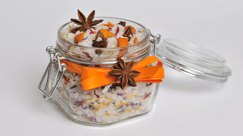 Deckelglas, gefüllt mit Badesalz, umwickelt mit einer orangefarbenen Schleife