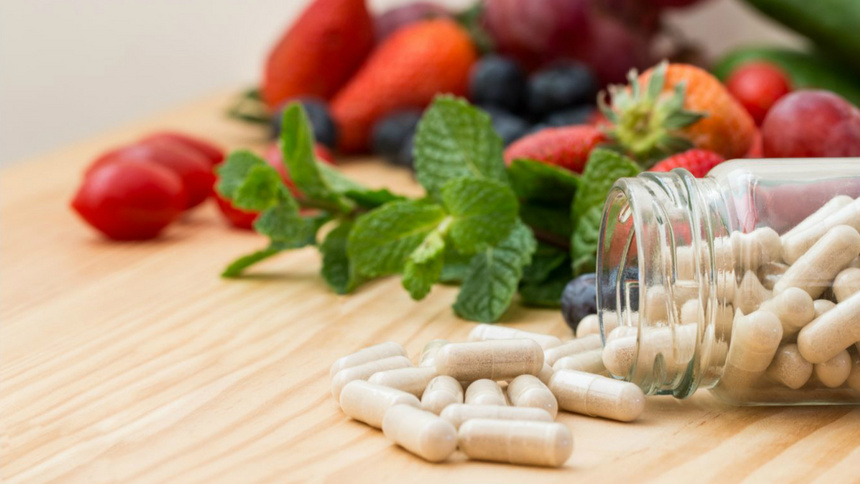 Alimentation substances vitales refroidissements vitamine C zinc: Un flacon de comprimé renversé. Il y a beaucoup de fruits en arrière plan