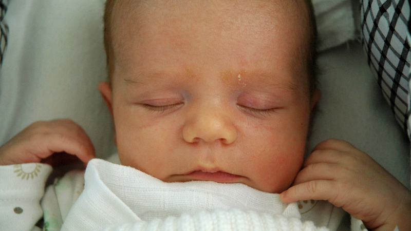 Petite enfance peau bébé soins: un bébé dort les poings levés