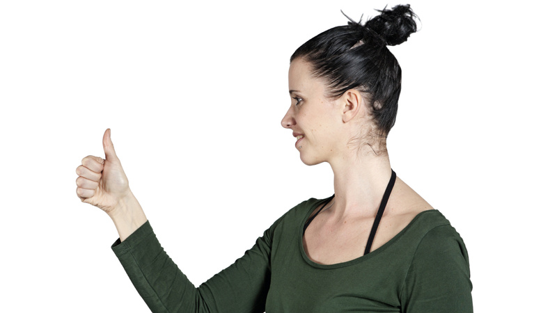 Une femme regarde son pouce qu'elle tient devant elle