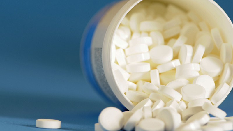 Naturheilkunde, Schüssler Salze: Plastikdose mit Schüssler Salz Tabletten liegt auf dem Rand, der Deckel ist offen.