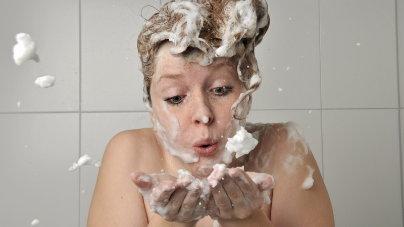 Eine Frau mit Shampoo in den Haaren.