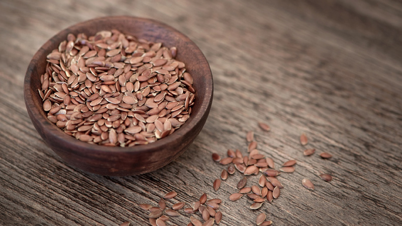 Des graines de lin dans un bol en bois