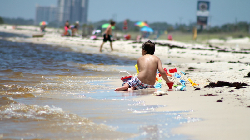 Noyades conseils règles bain: un enfant vu de dos au bord de la mer.