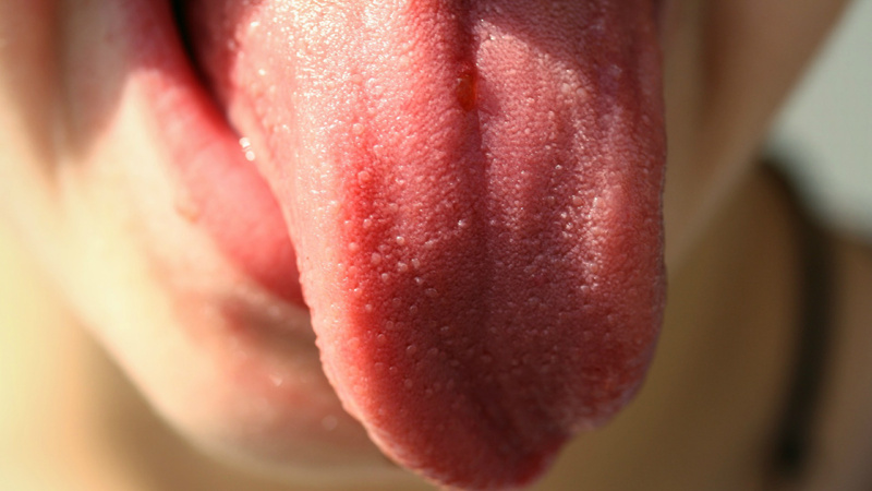 Un visage qui tire une langue bien rouge