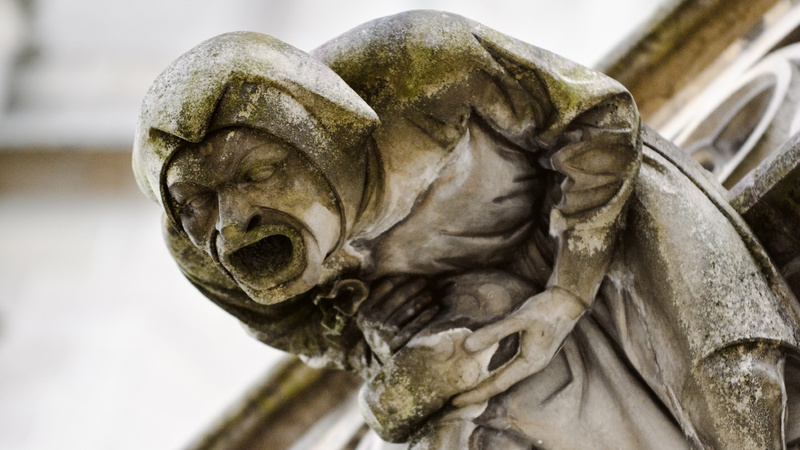 Schmerz, Phantomschmerz, psychosomatischer Schmerz: Statue, die sich vor Schmerzen gekrümmt nach vorne neigt.