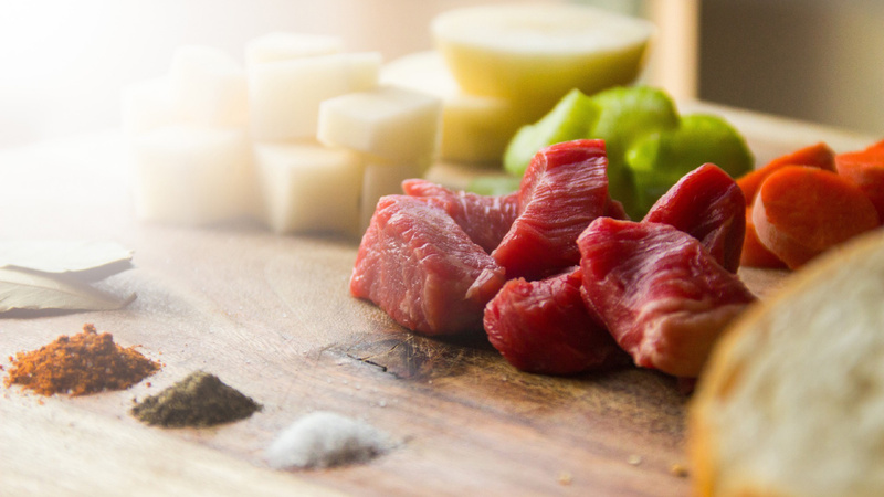 Ernährung, Mineralstoffe, Mikronährstoffe: geschnittenes Rindfleisch, davor Häufchen von Gewürzen auf einem Holzbrett