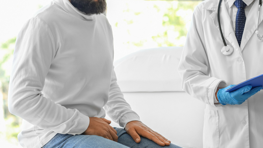 Cystite: un homme est assis avec la main sur la cuisse.