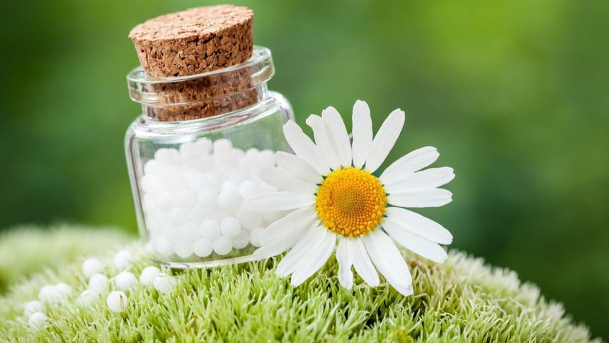 Des globules homéopathiques posés sur de l'herbre