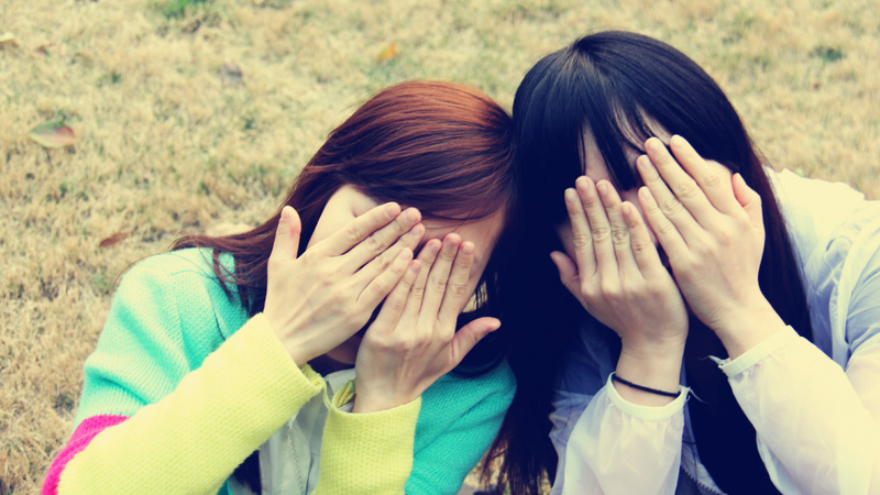 Acné boutons conseils: deux jeunes filles se cachent le visage dans leurs mains.