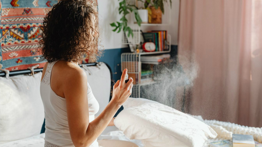 Une femme appuie sur un spray d'ambiance.