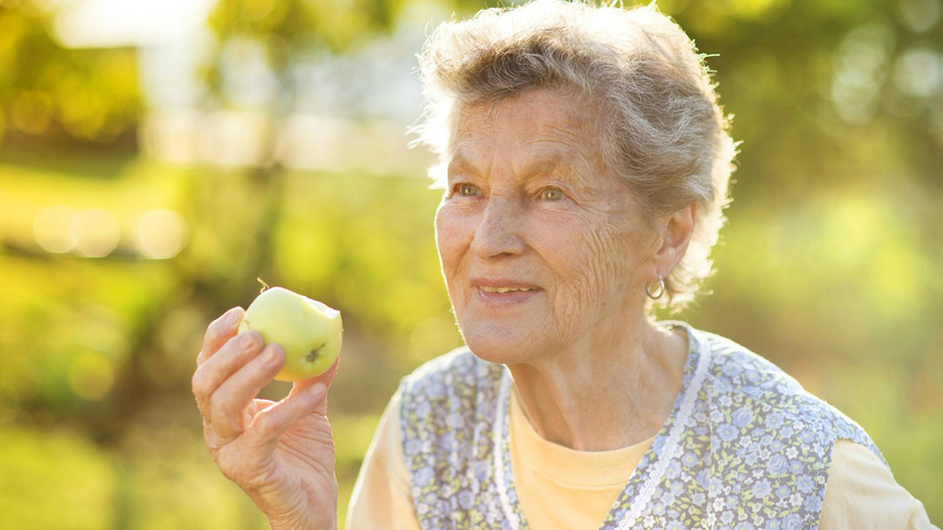 Ernährung, Vitamine, Alter: ältere Person, die einen Apfel isst