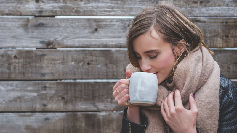 Eine Frau trinkt eine Tasse Tee.