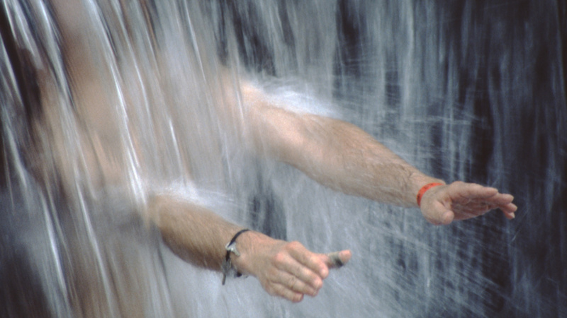 Jemand hàlt seine Arme unter einen Wasserstrahl.