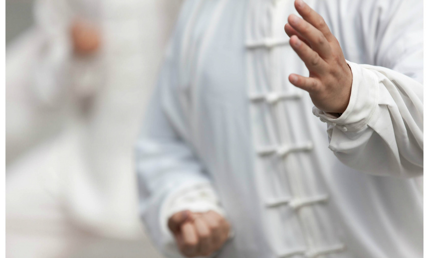 Un homme en costume blanc pratique le tai chi