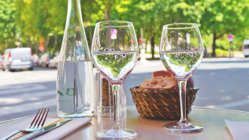 Ernährung, Wasser, trinken: Tischchen in einem Strassencafé, zwei Gläser gefüllt mit Wasser, daneben eine volle Karaffe, Besteck und Servietten