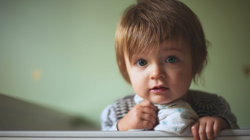 Le visage d'un enfant qui tient un mouchoir dans la main