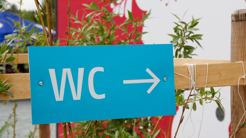 Inkontinenz, Blasenschwäche: Ein blaues Schild, darauf die Buchstaben «WC» und ein Pfeil