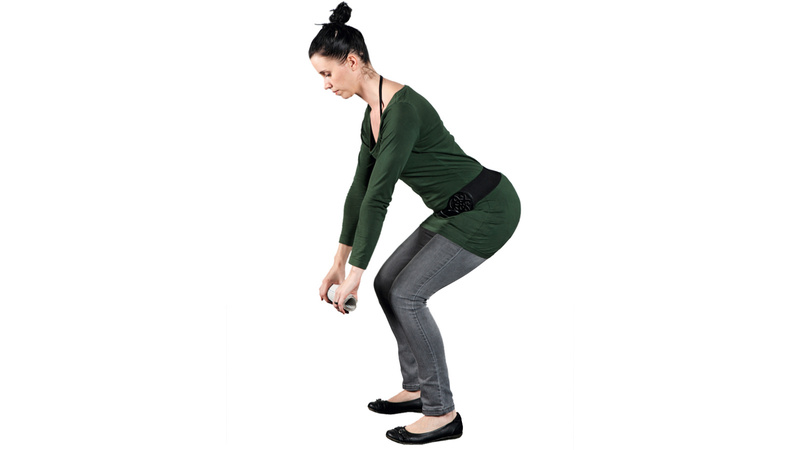 Une femme se baisse pour ramasser un objet