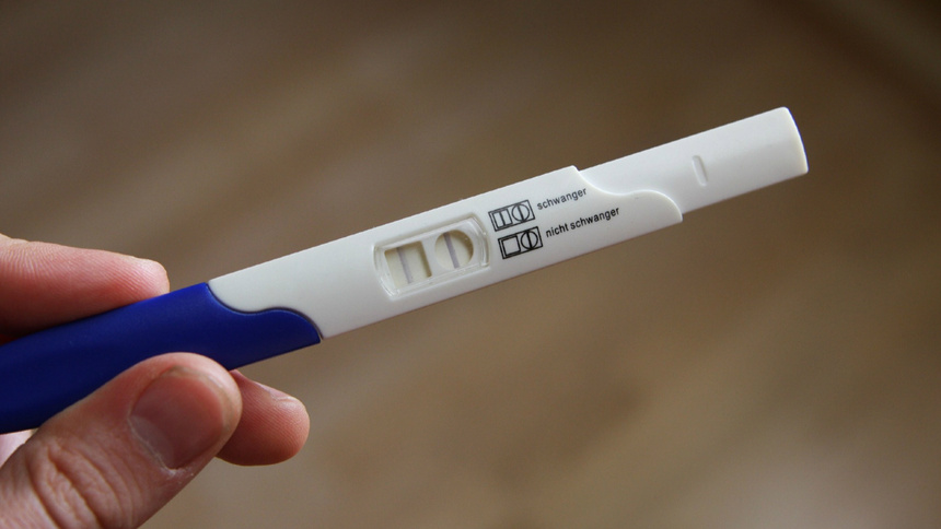 Eine Hand hält einen Schwangerschaftstest