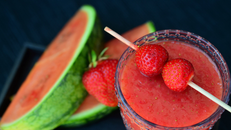 Alimentation tendances smoothies interview: un smoothies avec des fraises fraîches posées sur le verre.