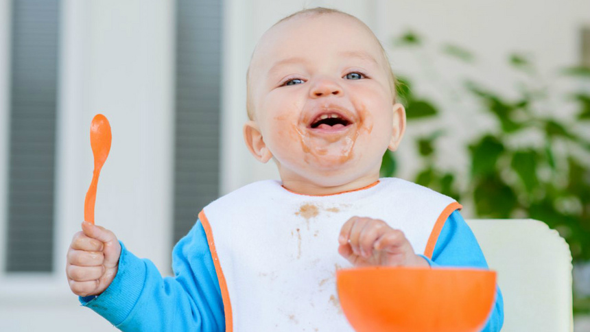 Ernährung, Babynahrung, Brei: Ein kleines Kind, das Kartoffelpüree isst und es um den Mund herum hat