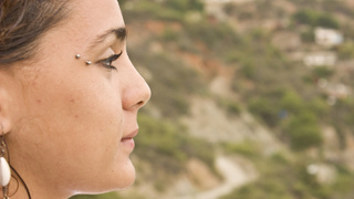 Une jeune femme de profil qui regarde au loin.